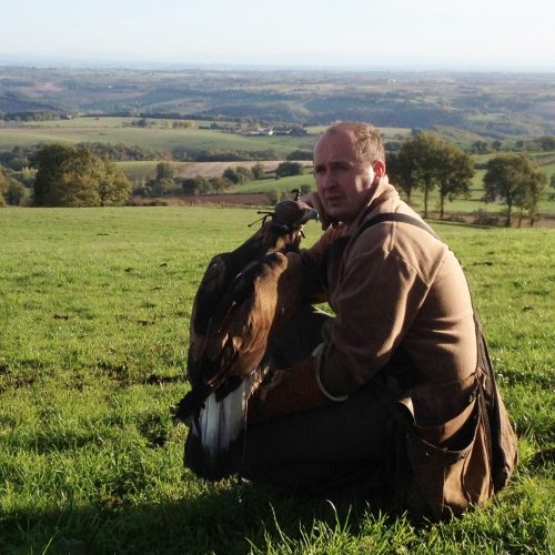 Portrait de Nicolas Hirissou propriétaire vigneron du Domaine du Moulin à Gaillac, avec son faucon sur le bras dans un pré